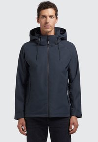 Chaqueta impermeable de color navy con capucha, cremallera frontal vertical, dos bolsillos laterales y cordones ajustables en el cuello. Textura suave y mate.