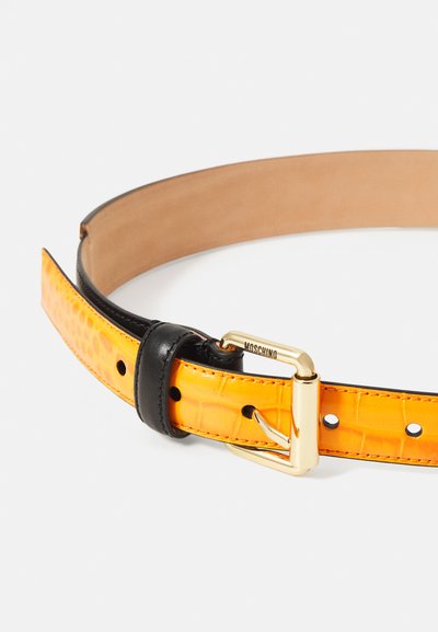Curea din piele galbenă cu model de crocodil, cu accente din piele neagră, cataramă aurie și cusături vizibile. Design clasic pentru curea.