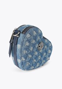Sac en denim en forme de cœur avec un motif matelassé bleu, un accent argenté et une fermeture à double zip. Il est doté d'une bandoulière en cuir et de ferrures métalliques.