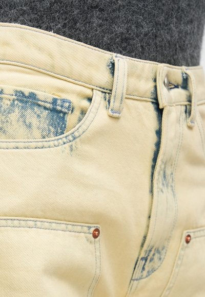 Φωτεινό κίτρινο τζιν παντελόνι με ξεθωριασμένες μπλε λεπτομέρειες. Διαθέτει κλασικό σχεδιασμό με πέντε τσέπες και λεπτομέρειες από χαλκό.