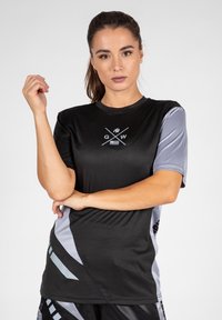 Zwart en grijs sportshirt met korte mouwen, een ronde halslijn en een grafisch logo. Glad materiaal met contrasterende zijkanten.