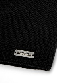 Czarna dzianinowa czapka z miękkiej przędzy, z metalową srebrną metką z wytłoczonym napisem "WITTCHEN", prezentująca delikatną prążkowaną fakturę.