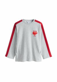 Siva jopa z rdečimi trakovi na ramenih. Na njej je natisnjen napis "PARIS AMOUR 1990" v rdeči barvi. Mehka tekstura, dolgi rokavi, stranski razporki za udobje.