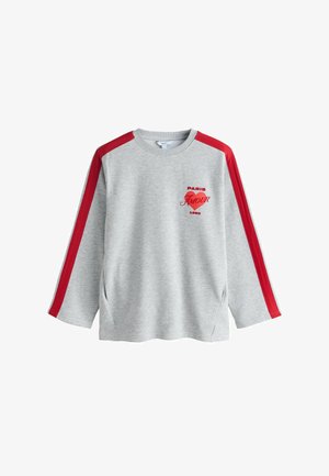 Sudadera gris con rayas rojas en los hombros. Presenta la inscripción "PARIS AMOUR 1990" en rojo. Textura suave, mangas largas, aberturas laterales para facilitar el movimiento.