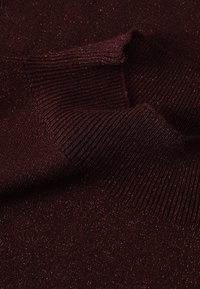 Tissu en maille bordeaux avec une subtile étincelle métallique, présentant une texture côtelée et des bords lisses, affichant une profondeur de couleur et de détail.