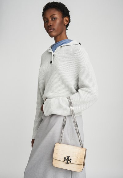 Light gray ribbed knit sweater with a drawstring collar, paired with a pale gray skirt and a cream faux-crocodile handbag featuring a chain strap.