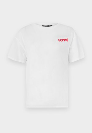 Λευκό βαμβακερό μπλουζάκι με στρογγυλή λαιμόκοψη και κοντά μανίκια· διαθέτει κόκκινο κείμενο "LOVE" στην αριστερή περιοχή του στήθους. Απλός σχεδιασμός, κανονική εφαρμογή.