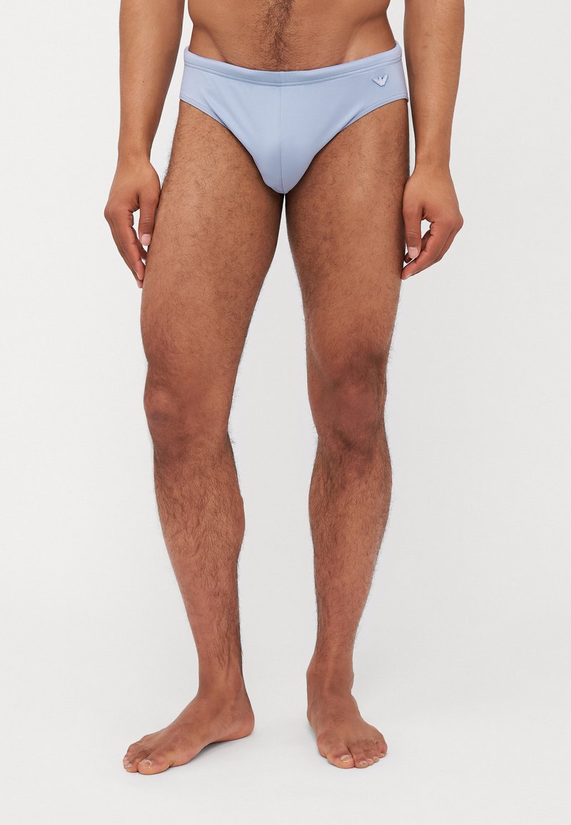 Svetlo modri kopalni hlački iz gladkega materiala, z nizkim pasom in majhnim logotipom na sprednji strani.