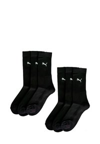 Schwarze Baumwollcrew-Socken mit gerippter Textur, ausgestattet mit drei kleinen weißen Puma-Logos am Bündchen, verkauft in einem Pack mit vier Paaren.
