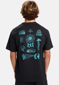 Camiseta de algodón negra con diseños gráficos turquesas, que incluyen símbolos y texto, en la parte posterior. Diseño de mangas cortas y cuello redondo.