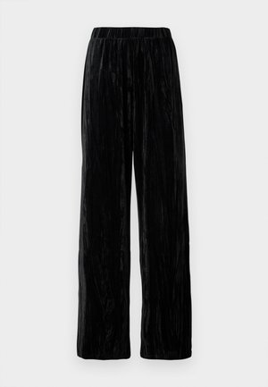 Zwarte wijde fluwelen broek met een elastische tailleband, weergegeven tegen een effen lichte achtergrond.