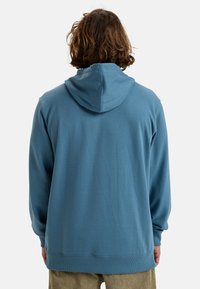Blue hooded sweatshirt made of soft fabric, featuring a relaxed fit, ribbed cuffs, and a drawstring hood. Plain design without patterns.
