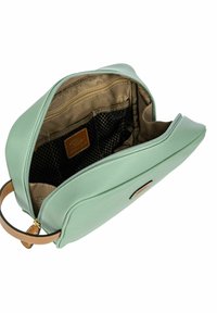 Bolso de cuero verde menta con textura suave, cierre de cremallera y asa de cuero marrón. El interior cuenta con un forro beige y bolsillos de malla.