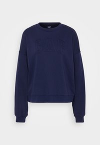 Sudadera de forro polar azul marino con un logo texturizado de "GAP" en la parte frontal, cuello redondo, mangas amplias y puños y dobladillo de canalé.