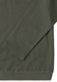 Manche longue et ourlet inférieur d'un pull en maille vert olive avec des coutures fines et régulières, ainsi que des poignets et une bande inférieure côtelés.