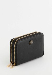 Portefeuille en cuir noir avec deux zips dorés, surface texturée et un accent logo rond à l'avant. Forme rectangulaire compacte.