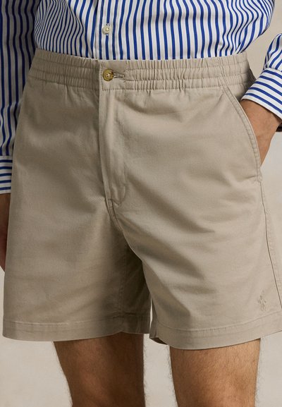 Béžové bavlněné šortky s elastickým pasem a předním knoflíkem. Mají boční kapsy a malý detail loga na lemu.