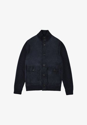 Granatowy kardigan ze skóry i dzianiny z prążkowanym kołnierzem, pięcioma guzikami i dwoma naszywanymi kieszeniami z przodu. Gładka faktura z kontrastowymi rękawami z dzianiny.