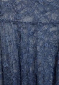 Kék csipkeanyag virágmintával és finom hálós textúrával, átlapoló rétegekkel és áttetsző területekkel.