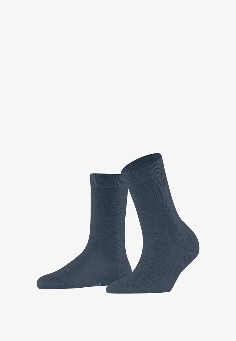 Chaussettes bleu foncé avec un motif en chevrons, fabriquées à partir d'un matériau texturé, avec des bords côtelés et une zone de orteil renforcée.