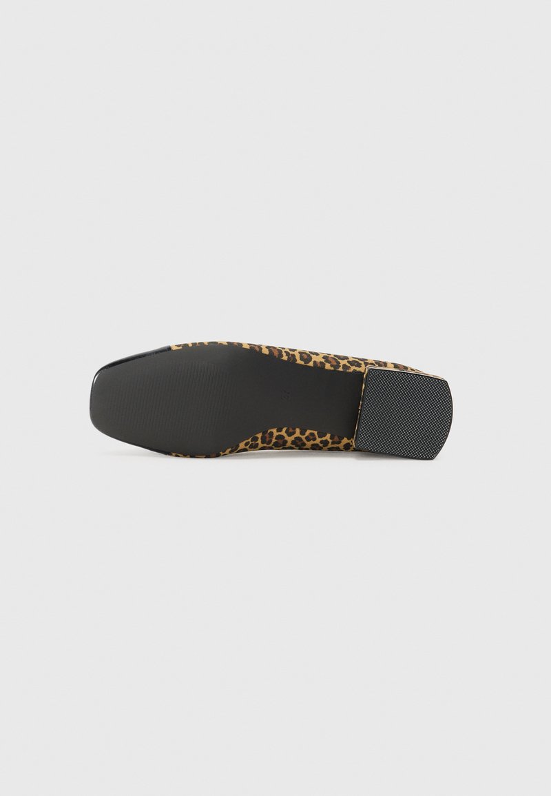 Zapato de tacón alto con estampado de leopardo, con una punta negra brillante y un tacón negro texturizado. La parte superior presenta una tela suave y estampada.