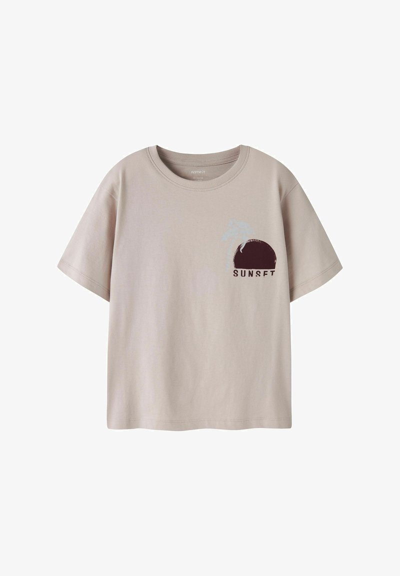 Beež lühikeste varrukatega T-särk ümara kaelusega, millel on tume päikeseloojangut kujutav graafika ja hele palmipuu vasakul rinnal koos sõnaga "SUNSET".