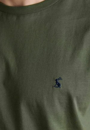 Olive green crew neck shirt with small dark blue embroidered rabbit logo on the left chest area.