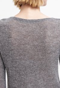 Pull gris en maille avec une texture douce, doté d'un décolleté large et de manches longues, montré de dos.