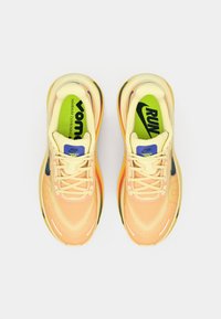 Ανοιχτό κίτρινο αθλητικό παπούτσι με υφασμάτινο επάνω μέρος με υφή, πολύχρωμες λεπτομέρειες και επενδεδυμένη γλώσσα. Διαθέτει μεγάλο λογότυπο στην πάτο και πολύχρωμη σόλα.