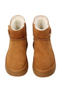 Brązowe zamszowe botki za kostkę z miękką kremową futrzaną podszewką, okrągłym noskiem i brązową gumową podeszwą. Zapięcie na boczny guzik.