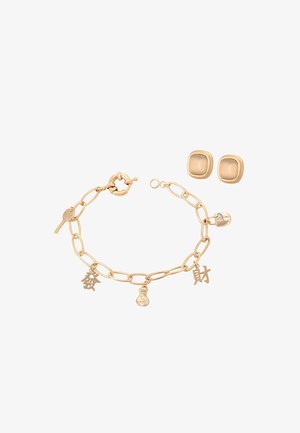 Kultasävyinen ketjupolvisormus, jossa on avain-, rahasäkki- ja kiinalaisilla merkeillä varustetut riipukset, yhdistetty neliönmuotoisten kultasävyisten nappikorvakorujen sarjaan.