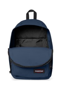 Zaino in tessuto blu navy con chiusura a pattina, zip nera, patch con logo e un ampio interno con tasca in rete.