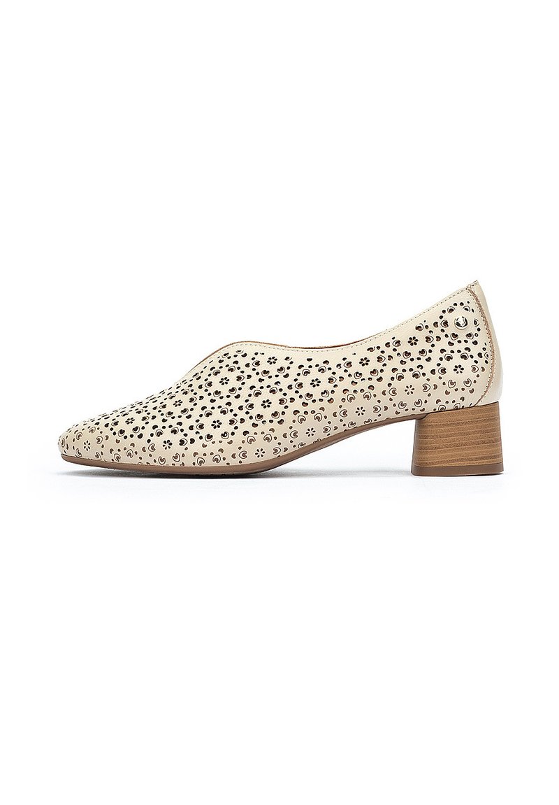 Chaussure en cuir perforé beige avec un embout pointu et un talon en bois cylindrique bas, présentant une surface texturée.