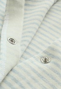 Tela a rayas azul claro y blanca con textura suave, que presenta botones a presión plateados. Costura detallada en los bordes.