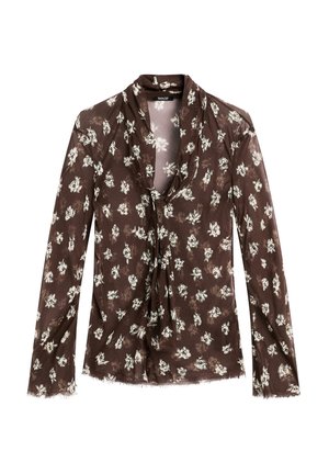 Blouse florale marron à manches longues, avec un décolleté drapé, un motif floral blanc et des franges au niveau de l'ourlet.