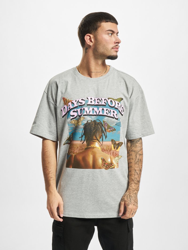 Camiseta de algodón gris con un gran gráfico colorido de mariposas y el texto "DÍAS ANTES DEL VERANO". Corte holgado con mangas cortas.
