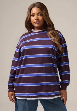 Bordeaux lange mouw top met blauwe en witte horizontale strepen, met een ronde halslijn en een ontspannen pasvorm, laag over een witte shirt.