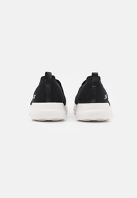 Black mesh sneakers with a textured finish, white rubber soles, and small logos on the sides. Features pull tabs for easy wear.