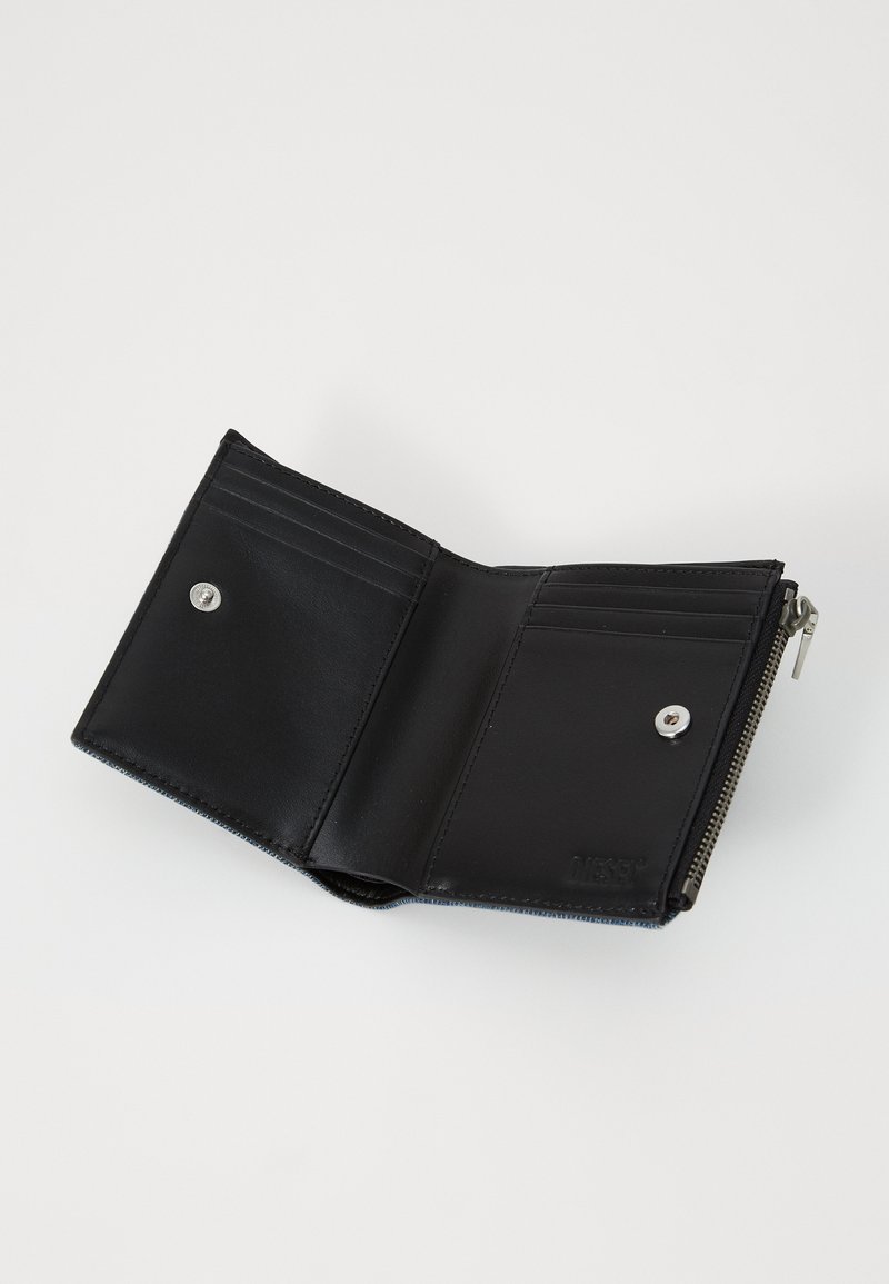 Portafoglio in pelle nera con chiusura a zip, multiple fessure per carte e bottone a pressione. Texture liscia con dettaglio di branding impresso.