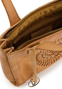 Tote aus braunem Leder mit aufwendigen Durchbruchs-Mustern, einem Reißverschluss-Hauptfach und einem mit Stoff ausgekleideten Innenraum. Verfügt über einen dekorativen Trageriemen.