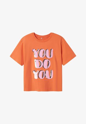 Pomarańczowa bawełniana koszulka z krótkim rękawem z napisem "YOU DO YOU" w dużych, cekinowych literach; litery w kolorach różowym, srebrnym i czarnym.