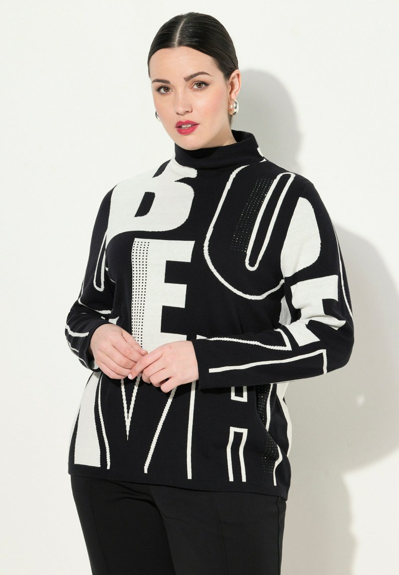 Maglione a collo alto in bianco e nero con tipografia audace e motivi grafici, realizzato in un morbido materiale a maglia con maniche lunghe.