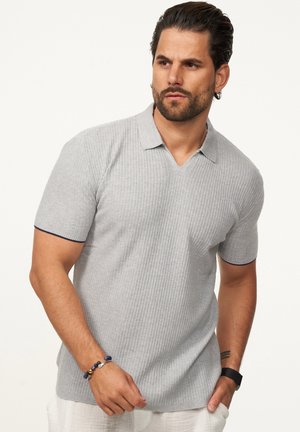 Graues, geripptes Poloshirt mit V-Ausschnitt und kurzen Ärmeln; mit marineblauen Akzenten an den Kragenrändern. Der Stoff wirkt weich und strukturiert.