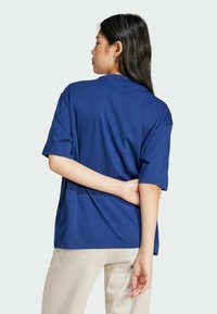 Navyblå oversized T-shirt med korte ærmer og rund halsudskæring, lavet af et glat stof. Har en løs pasform og et minimalistisk design.