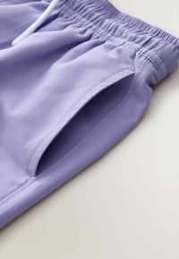 Svetlofialové šortky z hladkej tkaniny s elastickým pásom a bočnými vreckami s zaoblenými otvormi.