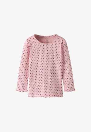 Light pink ribbed long-sleeve top with black polka dots. Features a scalloped hem and neckline. Made from soft cotton fabric.