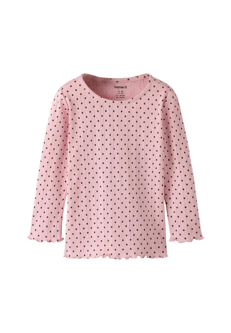 Jasnoróżowa prążkowana bluzka z długim rękawem w czarne groszki. Posiada falbaniasty dół i dekolt. Wykonana z miękkiej bawełny.