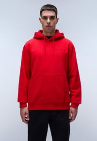 Felpa rossa con cappuccio, tasca frontale, cappuccio con coulisse e polsini a costine. Realizzata in tessuto con una superficie liscia, presenta un logo discreto sul petto.