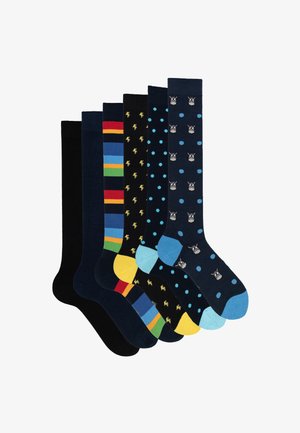 Set di sette paia di calze, con vari motivi: righe, pois e grafiche. I colori includono nero, blu, giallo e verde.