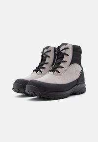 Botas de hiking cinzas e pretas, feitas de camurça e borracha, com um design de atacadores e solas robustas para tração.